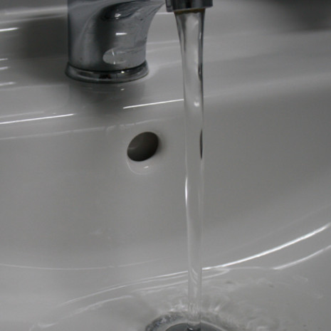 Wasserhahn mit fließendem Wasser als Zeichen für aktives Hygienemanagement
